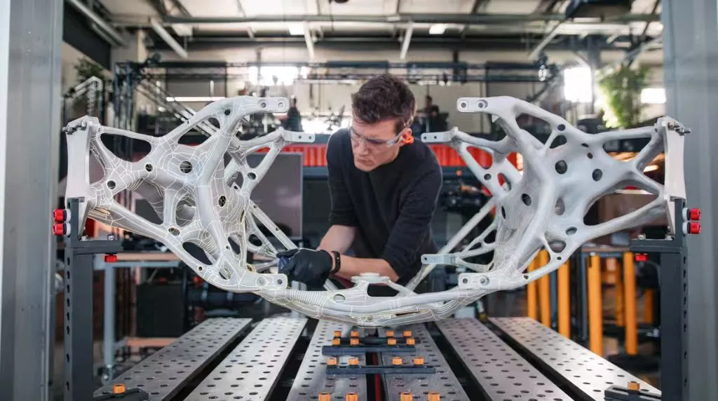 2026 Industrial 3D Printing Trends: What Manufacturers Need to Know Engineer inspecting large lightweight bionic 3D‑printed frame for automotive and aerospace industrial manufacturing